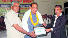 Satirist Halchal Haryanavi receives an award at a function in Rewari.