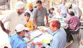 Ex-servicemen fill forms of passport applicants at the Regional Passport Office in Jalandhar on Thursday