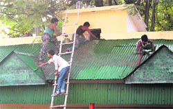 Workers paint the visitors waiting shed of the Civil Secretariat in Jammu 