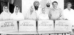 The beneficiaries with the sewing machines distributed by a bank officers organisation at Dera Bassi. 