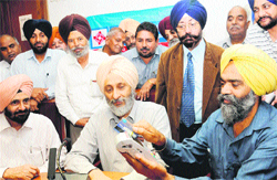 Punjab Food and Civil Supplies Minister Adesh Partap Singh Kairon watches the demonstration of a swipe card in Chandigarh on Friday. 