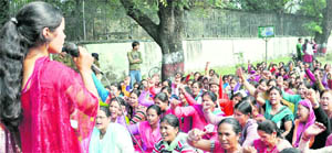 Anganwari workers from across the state stage a dharna on the Cantt road in Dehradun on Friday. 
