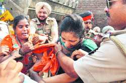 Assistant Town Planner Kamaljit Kaur (in green suit) being manhandled by a woman during a demolition drive in Ludhiana