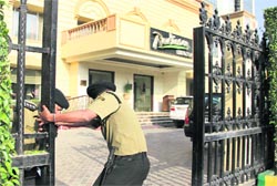 A security guard closes the gate of hotel Radisson after the DRI raid in Jalandhar on Saturday