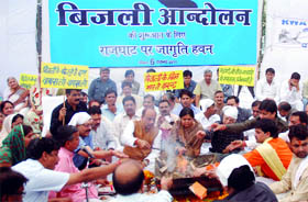 Activists of the BJP led by party's senior leader Vijay Goel perform a havan outside Rajghat to protest against the hike in power tariff, in New Delhi on Sunday.