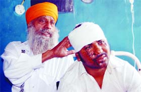 Injured Nishan Singh with his father in Guru Nanak Dev Hospital, Amritsar, on Monday
