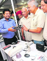 A man explains the working of a security gadget to senior citizens at the CII in Chandigarh on Monday.