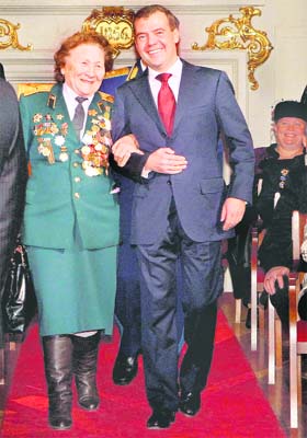 Russian President Dmitry Medvedev walks with WW-II veteran Nina Chervinskaya before a reception to mark the 70th anniversary of a historic World War II parade in Moscow on Monday