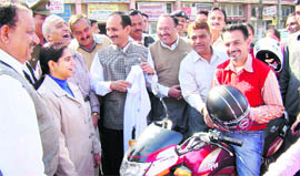 Free helmets and T-shirts being distributed to a traffic violator in Una on Tuesday.