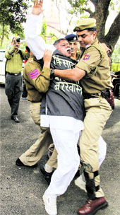 The police arrests a BJP MLA protesting against the anti-farmer policies of the state government, outside the civil secretariat in Jammu on Wednesday