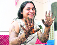 A girl, who is to get married on 11.11.11, shows off mehndi designs on her hands and arms. 