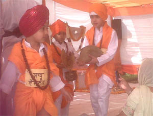 Children enact a scene from Guru Nanak's life pertaining to the 'sauda' (how to do business honestly) in a bid to learn Gurbani at a gurpurab celebration in Vasant Kunj, New Delhi, on Thursday