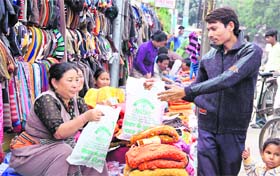 Tibetan refugees propagate message of Free Tibet through polybags in which they sell their products in Jalandhar