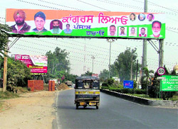A hoarding of the Congress party, with photograph of councillor and MCs advertisement sub-committee member Bharat Bhushan Ashu (third from left), pasted on a direction board, near Verka Milk Plant, on the Ferozepore road in Ludhiana