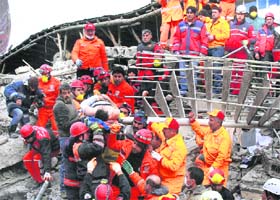 Rescue workers pull out a man from the rubble of a collapsed hotel in Van