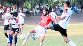 A player kicks the ball during a football match at the Sector 17 football stadium.