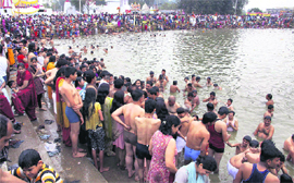 Devotees take a holy dip in a pond during the famous Jhiri fair at Kanachak village near Jammu on Thursday
