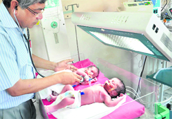 A doctor examines the lucky twins at a hospital in Jalandhar.