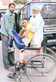 Kuldeep Singh Keepa held by relatives to sit on a wheel chair in Ludhiana.