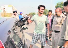 The victim, Abir Malhotra, uses a dummy bag to explain to the police how he was robbed of Rs 8 lakh on the road separating Sectors 48 and 49 in Chandigarh on Saturday