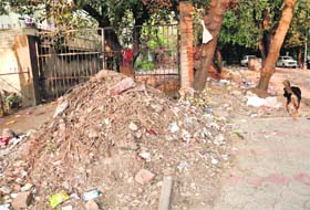 Piles of garbage lie on the rear of a house near Hotel Aroma at Sector 22, which is the entry to service lanes in the area