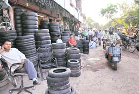 Shopkeepers have encroached on footpath by putting tyres on display at Burail market
