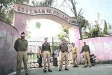 Policemen stand guard outside Goverment MAM College in Jammu on Saturday. The main gate of the college is also closed. 