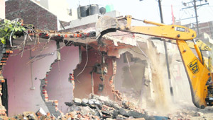  Demolition of illegal structures by the district administration in progress in Ambala Cantonment on Monday. 