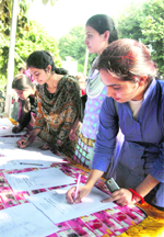 Girls participate in a signature campaign against the new recruitment policy at the University of Jammu.