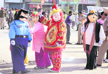 BJP workers dressed up as jokers, Charlie Chaplin and security guard, carrying party flags, amuse the crowd at the rally.