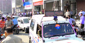 A crowd gathers where a girl jumped from a shop window to escape molestation by her employer in Karnal on Tuesday.