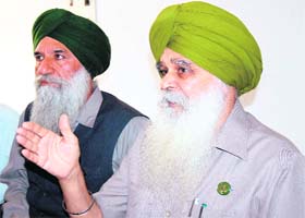 Mandi Board chairman Ajmer Singh Lakhowal (right) addresses a press conference in Amritsar on Tuesday