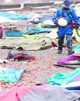 A riot police officer walks amongst tents as they remove members of the Occupy Paradeplatz movement in Zurich on Monday