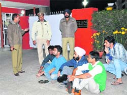Students sit with empty plates in front of the VCs residence to protest against hike in mess charges at Panjab University