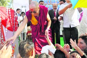 The Dalai Lama, Buddhist spiritual leader, greets people during a visit to an excavation site in Ambaran, near Akhnoor, on Wednesday