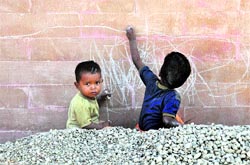 Two kids scribble on the boundary wall of Satluj Club in Ludhiana