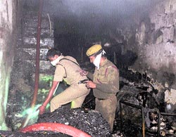Fire officials douse flames in the shop at Mani Majra on Thursday