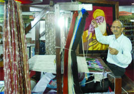 National award winner Khemraj Sundriyal weaves a thread painting at Haryana Pavilion at the trade fair in New Delhi on Thursday. 