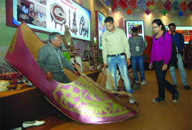 A king-size boot having a length of 9 ft and width of 3ft and weighing 30 kg is on display at Punjab Pavilion at Pragati Maidan in New Delhi on Thursday.