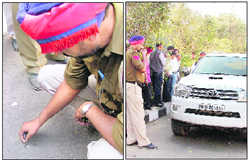 A policeman inspects a bullet mark on the road; and (right) the SUV from which the cash was robbed at gunpoint in Ludhiana on Thursday. 