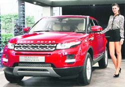 Model and Bollywood actress Nargis Fakhri poses with Jaguar Land Rovers new Range Rover Evoque at its launch in New Delhi on Friday. The SUV will be available in both 5-door (diesel) and coupe (petrol) variants with prices starting at Rs 44.75 lakh (ex-showroom Delhi)