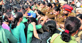 Women police personnel prevent health workers from protesting on the Ferozepur road in Ludhiana on Friday.