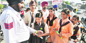 Children of an orphanage tie a band on the wrist of a policeman in Ludhiana on Thursday.