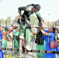 Protesting nurses make an attempt to jump over the gate of the Mini Secretariat in a bid to block vehicular traffic on Ferozepur Road, in Ludhiana on Friday.