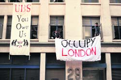 Anti-capitalist activists hang banners outside an empty office building in London