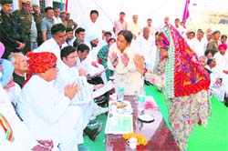 Chief Minister Bhupinder Singh Hooda accepts greetings of a rural woman during his campaign in Ratia