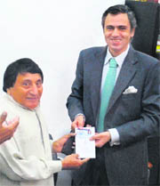 Minister for Transport Qamar Ali Akhoon hands over the driving licence to Chief Minister Omar Abdullah at the Regional Transport Office in Jammu on Saturday.