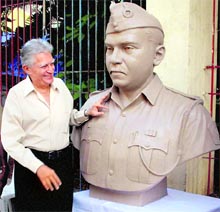 Artist Mikhail Yawalka stands next to a bust of 26/11 Mumbai terror attack martyr Tukaram Ombale in Mumbai on Saturday. The Mumbai police assistant sub-inspector was responsible for the capture of Lashkar-e-Toiba terrorist Ajmal Kasab alive