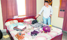 A neighbour shows scattered household items in the house of an elderly couple in Jalandhar on Sunday.