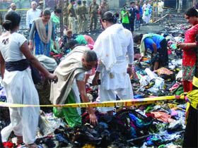 Members of the Indian eunuch community search for their belongings in the debris after the fire in New Delhi on Monday. 